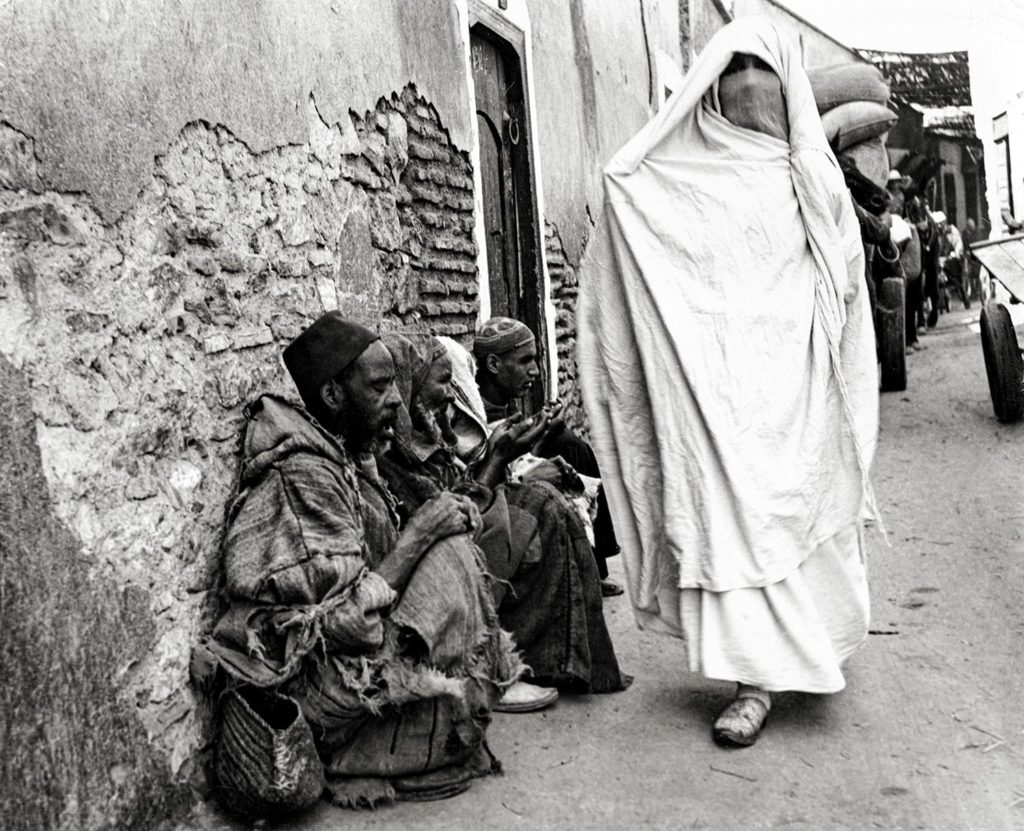 A veiled woman passes beggars, Fez, Morocco (c.1950s-60s)